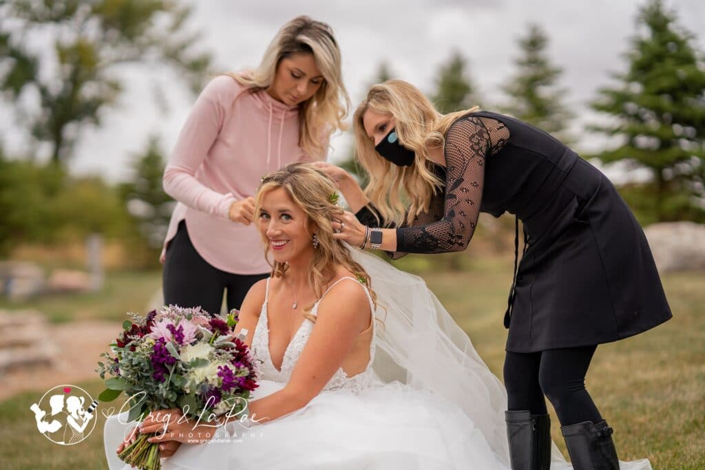 Wedding planner helping a bride with her veil.