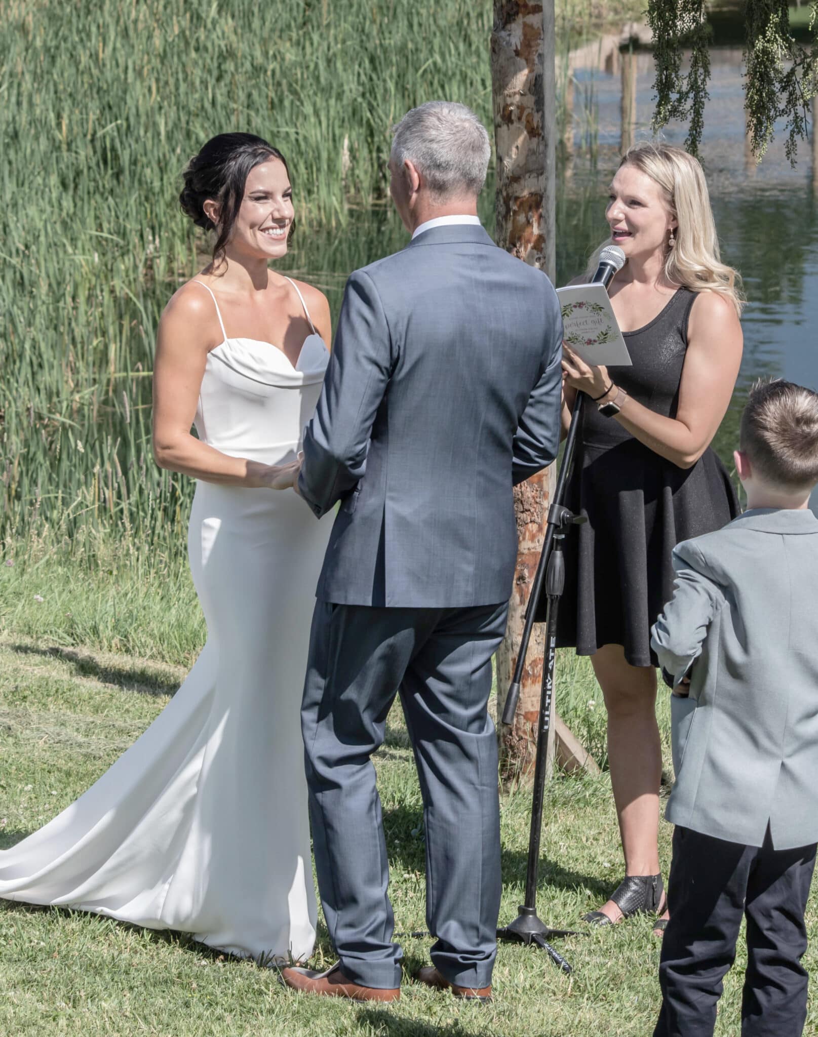 Bride and groom exchanging vows at lakeside wedding
