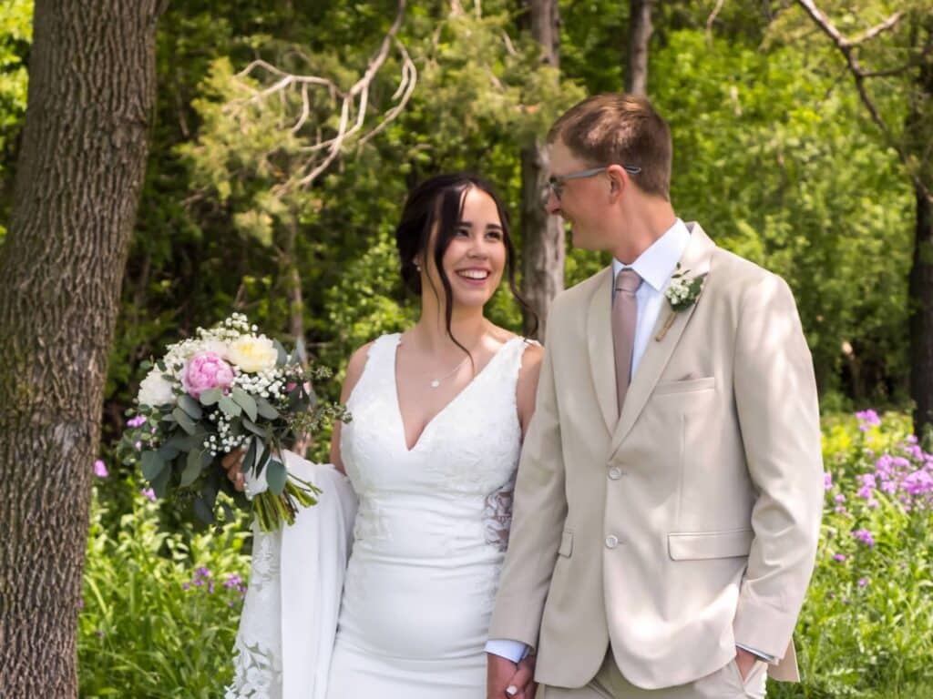 Bride and groom smiling outdoors on wedding day