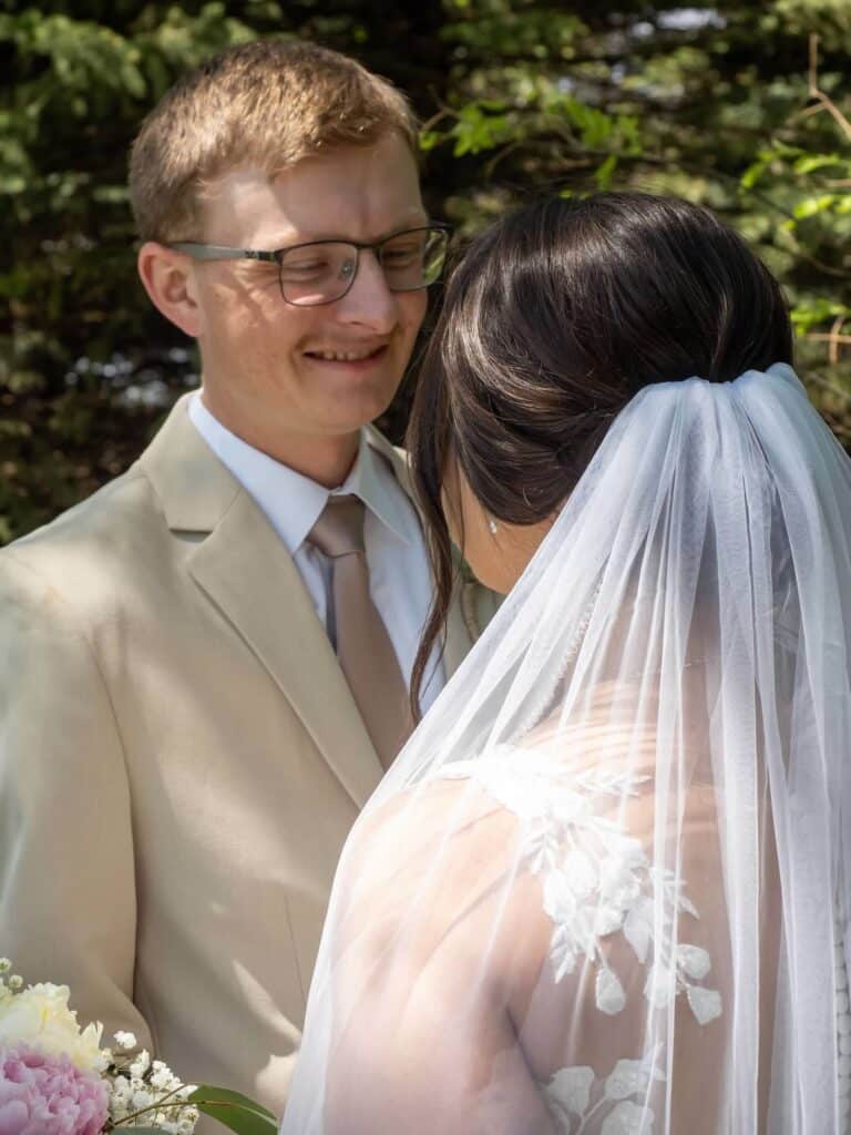 Bride and groom smiling during outdoor wedding ceremony