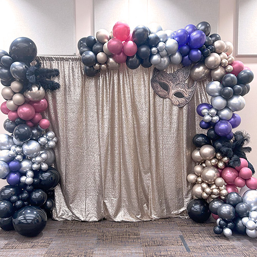 Balloon arch with silver curtain and mask