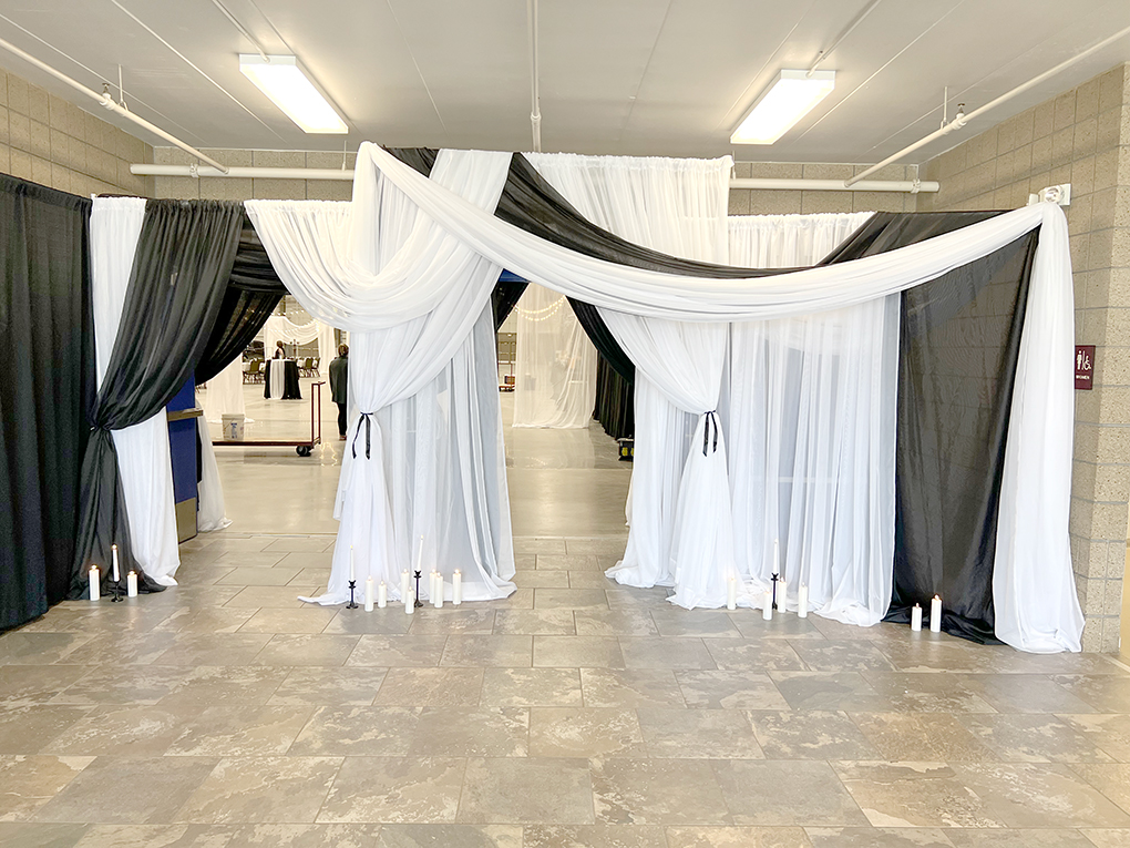 Black and white draped event entrance with candles