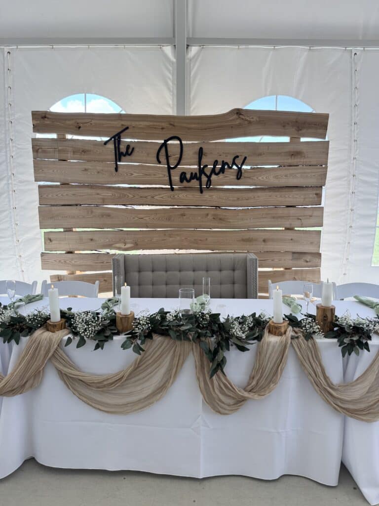 Rustic wedding sweetheart table with wooden backdrop