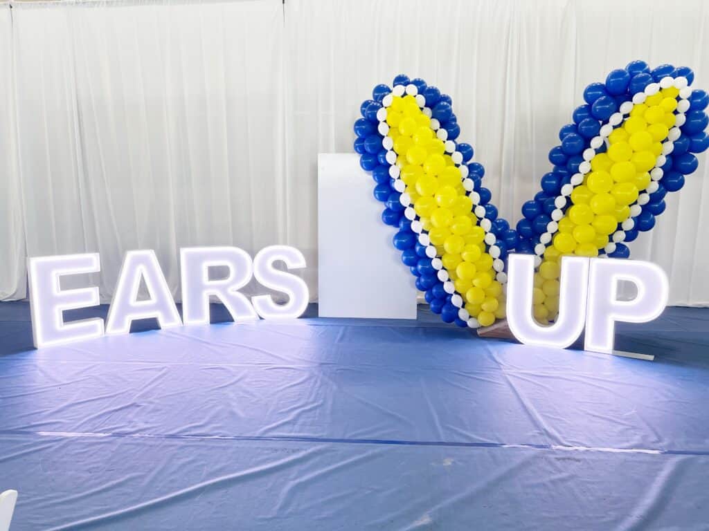 EARS UP marquee letters with balloon wings backdrop