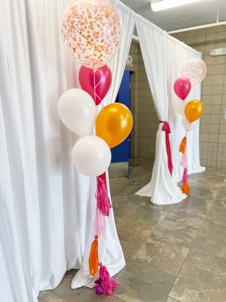 Colorful balloon bouquets against white draped curtains