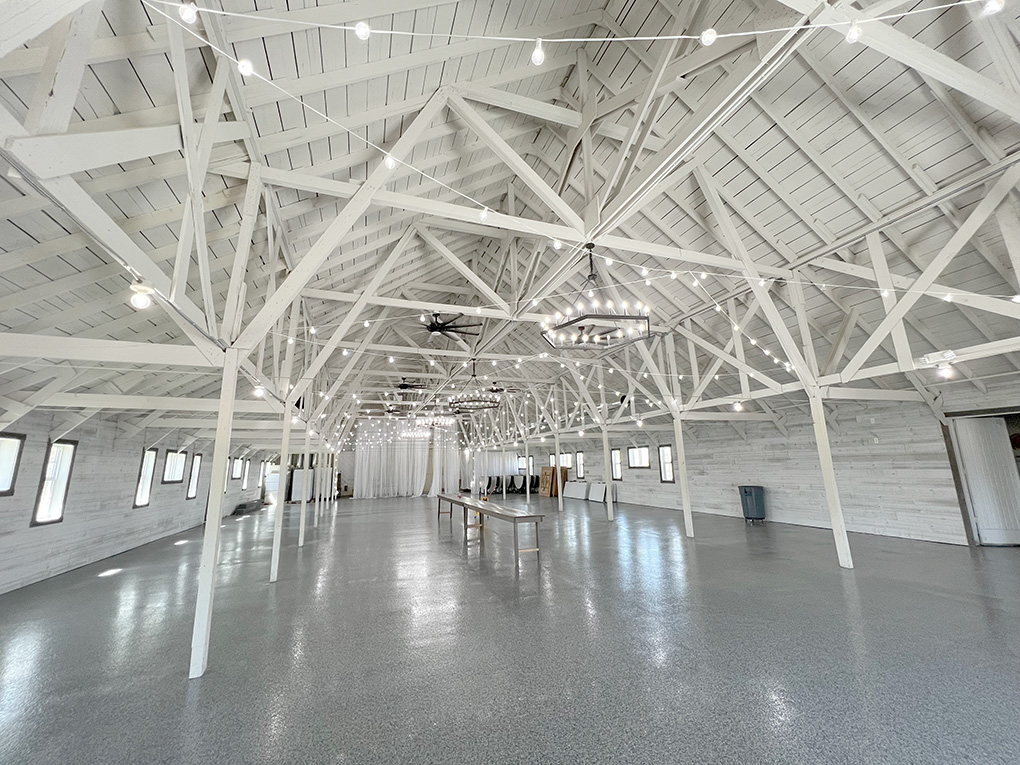 Spacious white barn interior with string lights