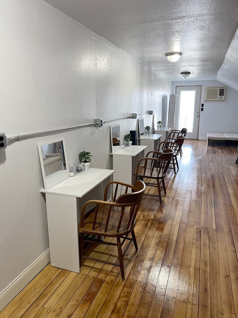 Row of vanity desks in narrow studio room