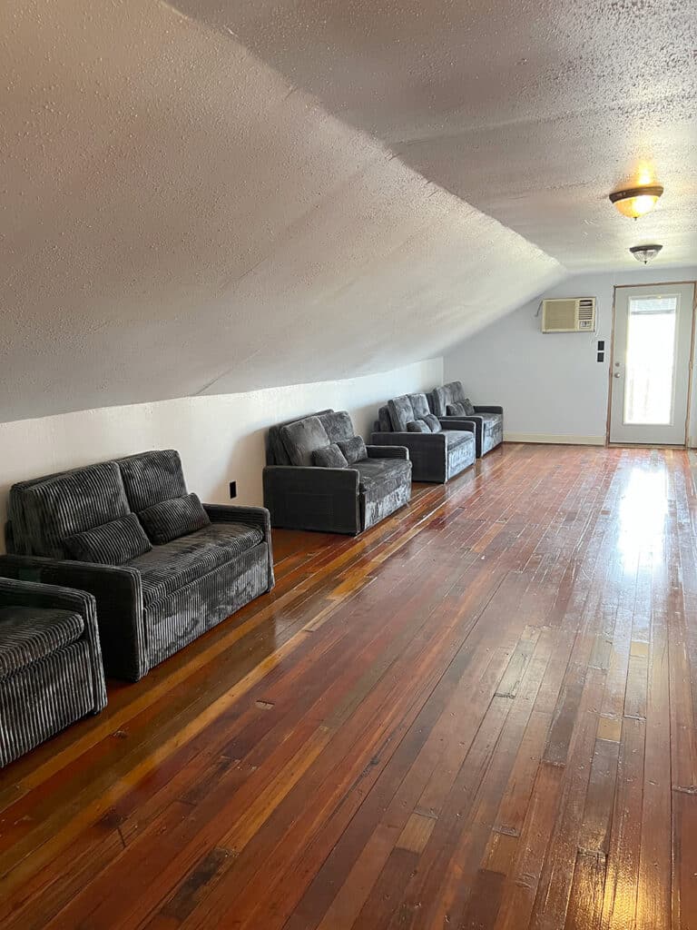 Attic room with slanted ceiling and gray sofas