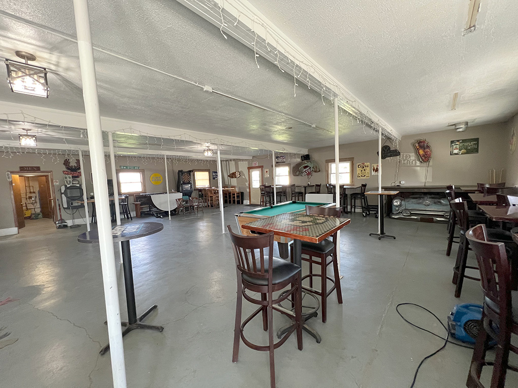 Spacious bar interior with pool table and high tables
