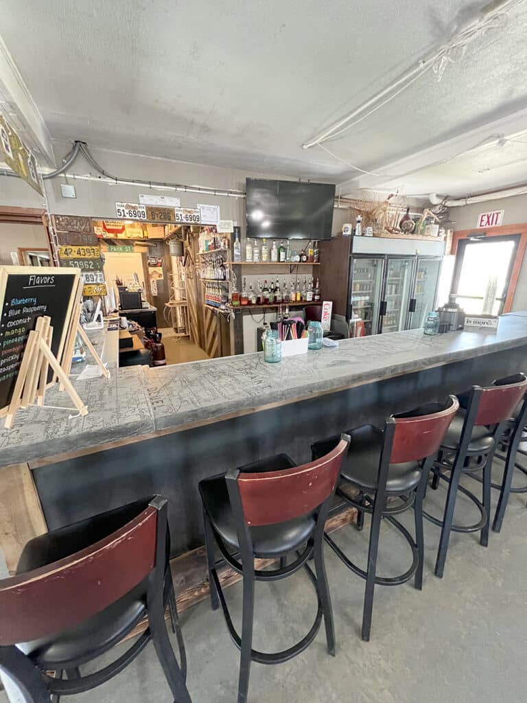 Rustic bar counter with stools and liquor shelves