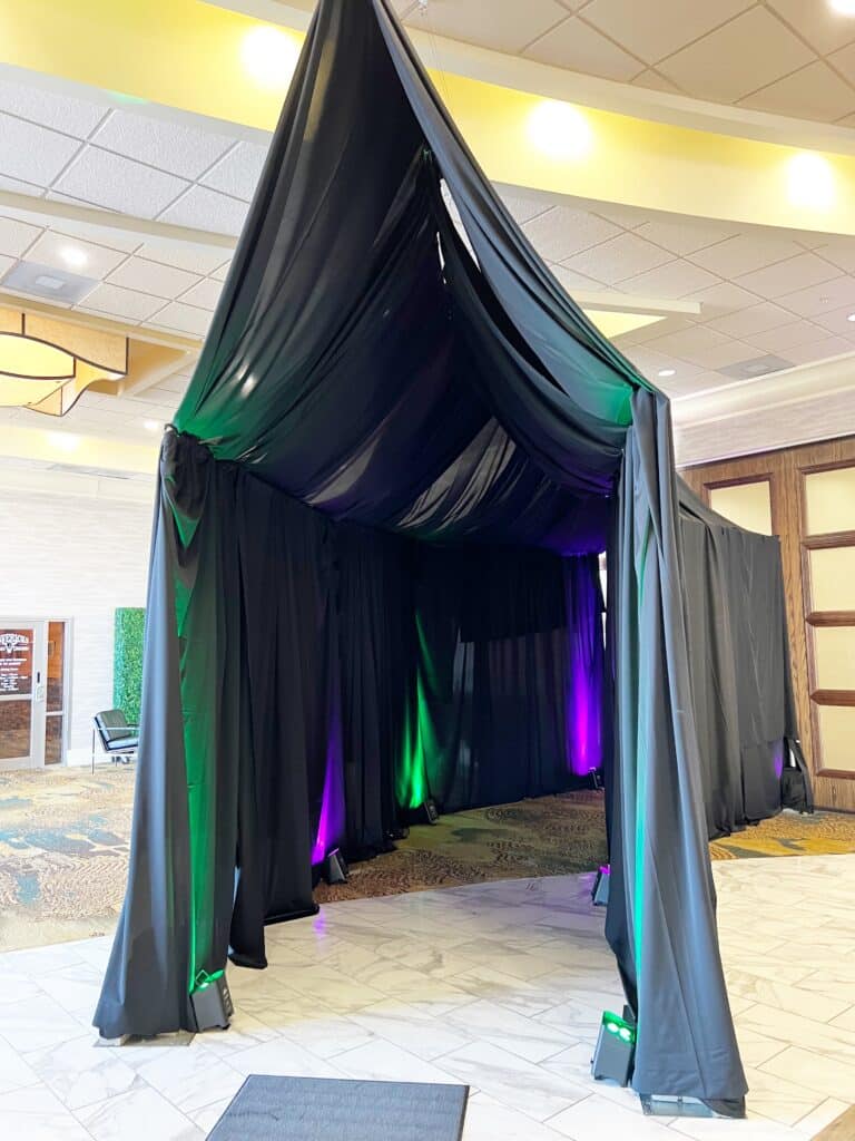 Black draped canopy with green and purple lighting