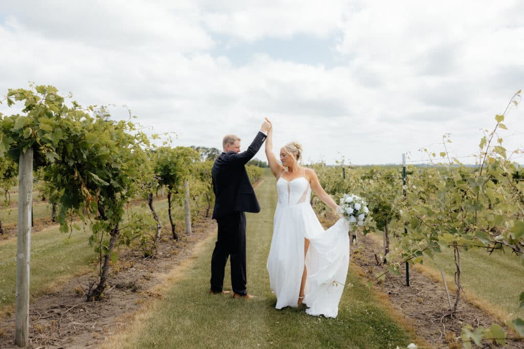Bride and groom embrace among vineyard vines