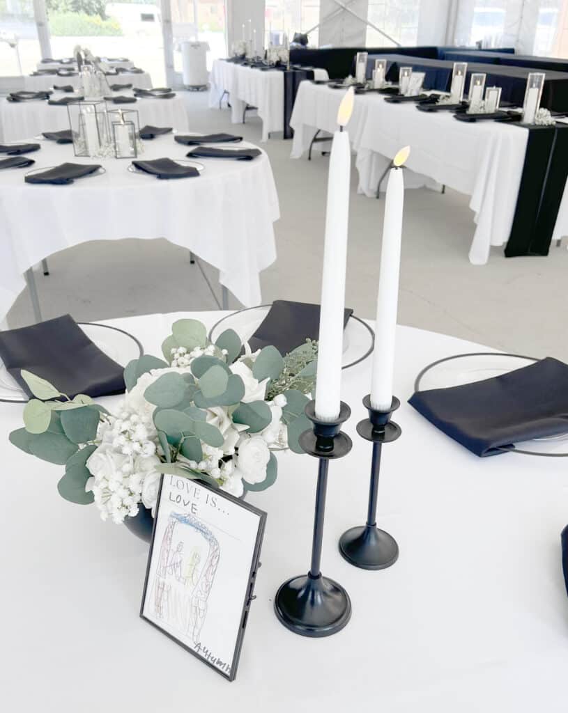 Elegant black-and-white wedding reception tables with candles and flowers