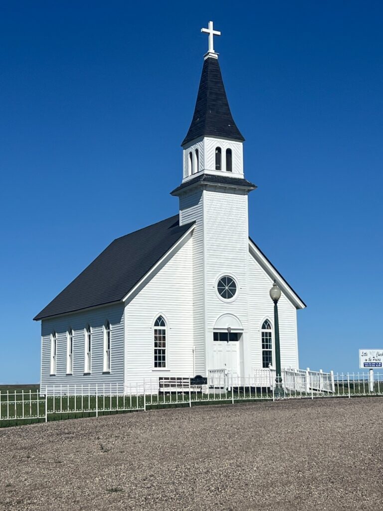 White wooden church with steeple and cross