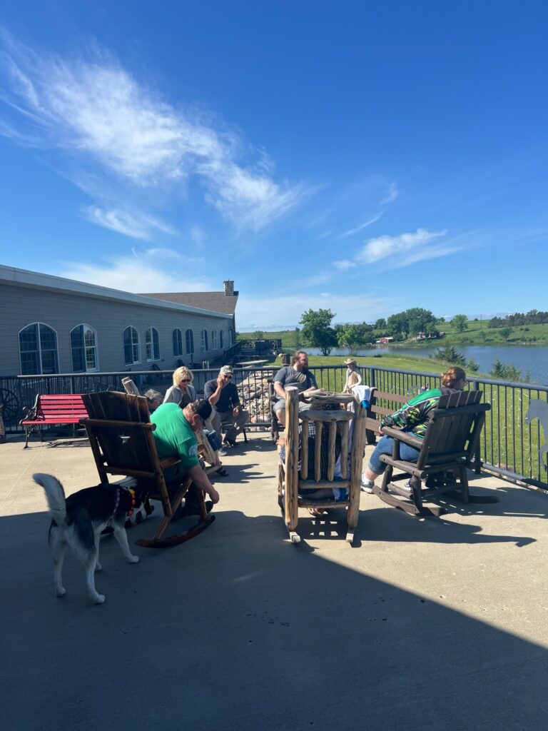 People relax on patio overlooking lake and countryside