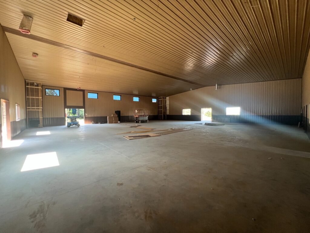 Large unfinished metal building interior with concrete floor