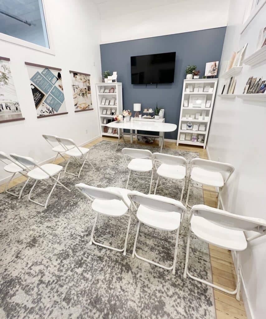 Small workshop room with chairs, desk, shelves, and television