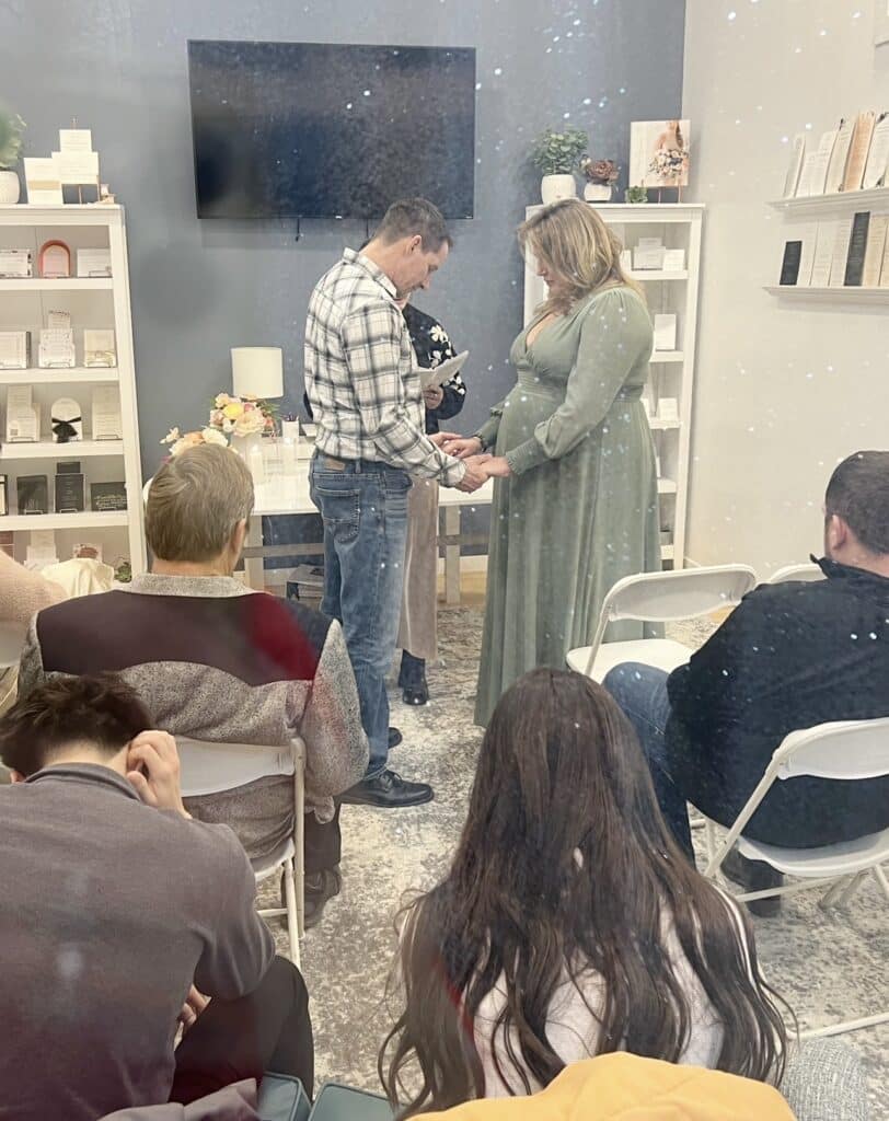 Couple holding hands during an intimate indoor ceremony