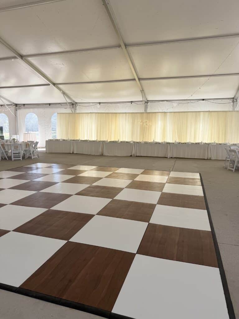 White event tent with tables and checkered dance floor