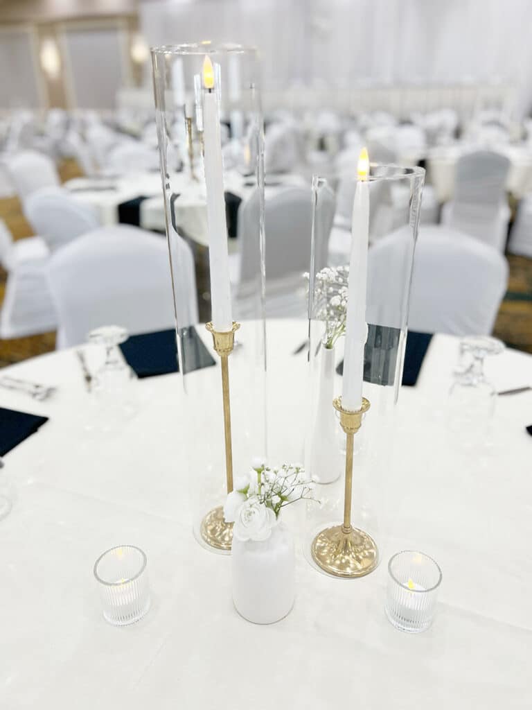 Elegant white wedding table centerpiece with candles and flowers