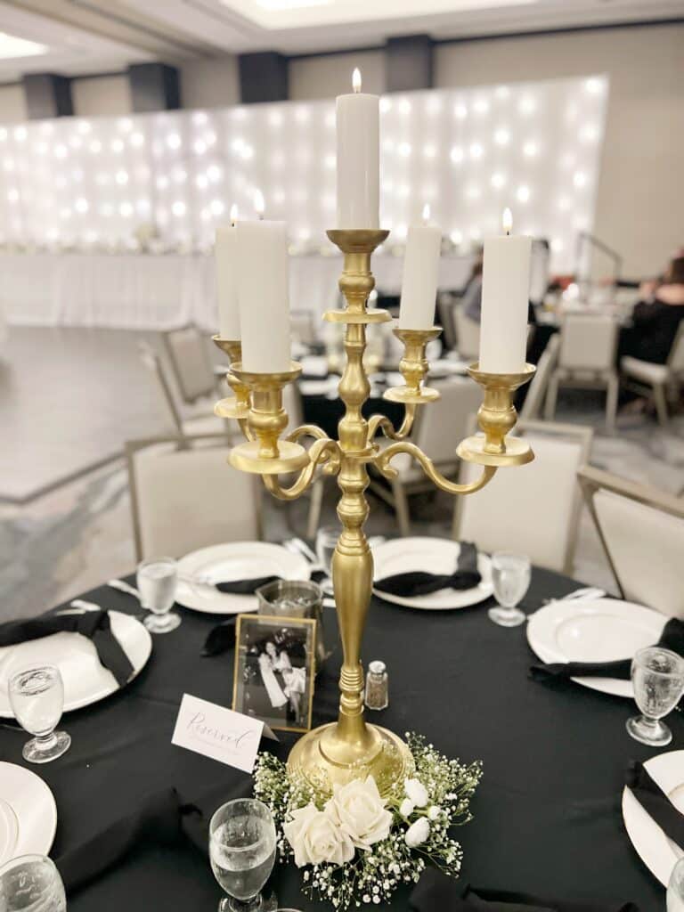 Gold candelabra with white candles on elegant banquet table