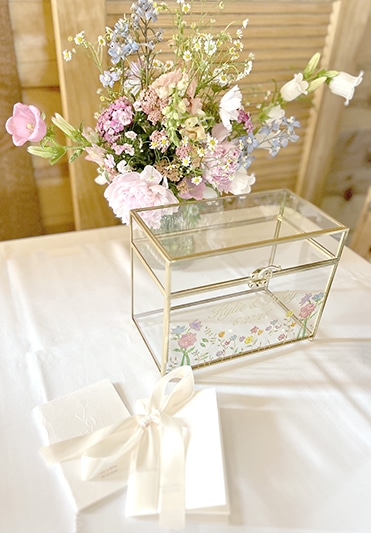 Pastel flowers beside glass card box and gift