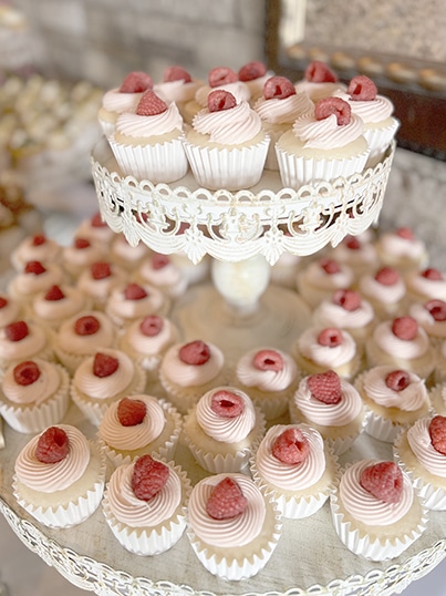 Raspberry-topped cupcakes on an ornate tiered dessert stand