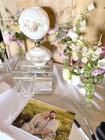 Rustic wedding table with flowers, photo, and guestbook
