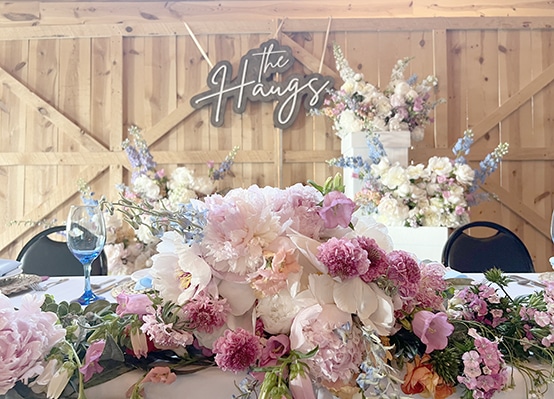 Pink floral wedding table beneath "The Hawgs" sign