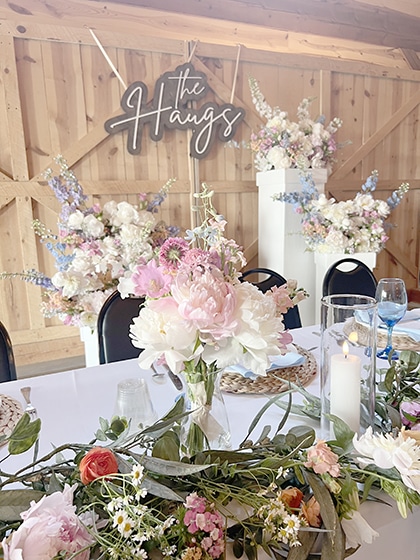 Floral wedding reception table beneath “The Hangs” sign