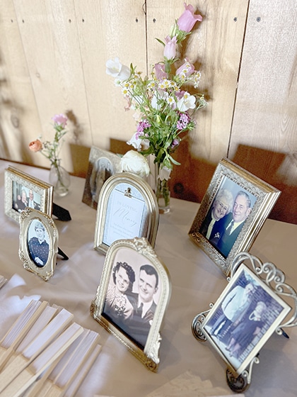 Framed family photographs and flowers on memorial display table