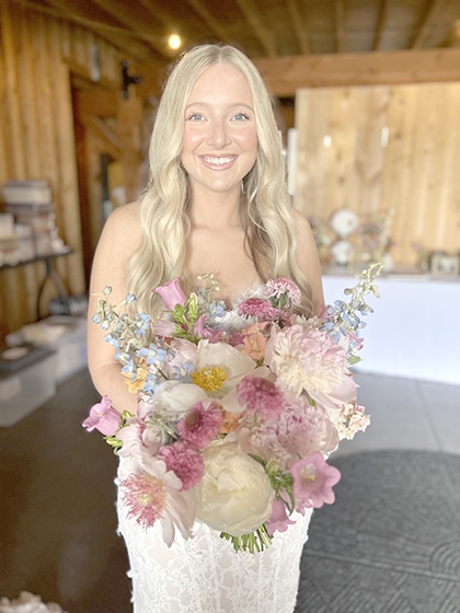 Smiling bride holding a pastel pink and white bouquet