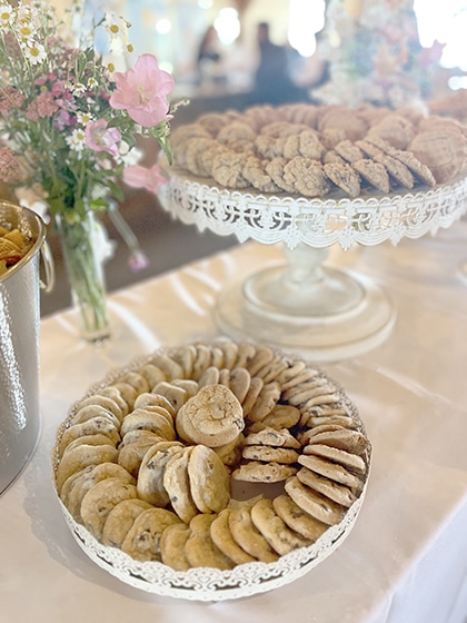 Elegant platters of assorted cookies beside fresh flowers
