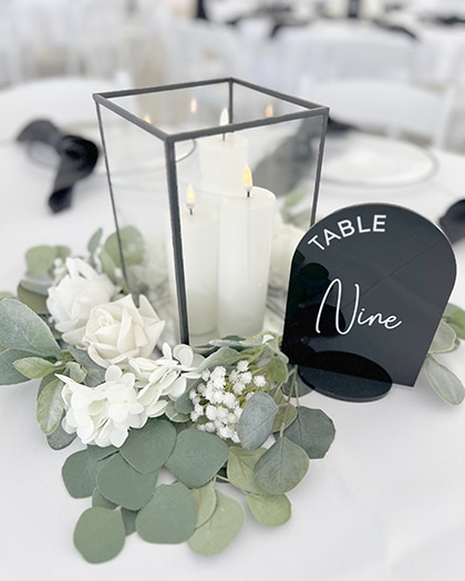 Wedding table centerpiece with candles, flowers, and table nine sign
