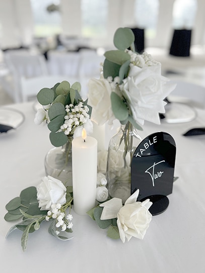Elegant white floral wedding centerpiece with table two sign