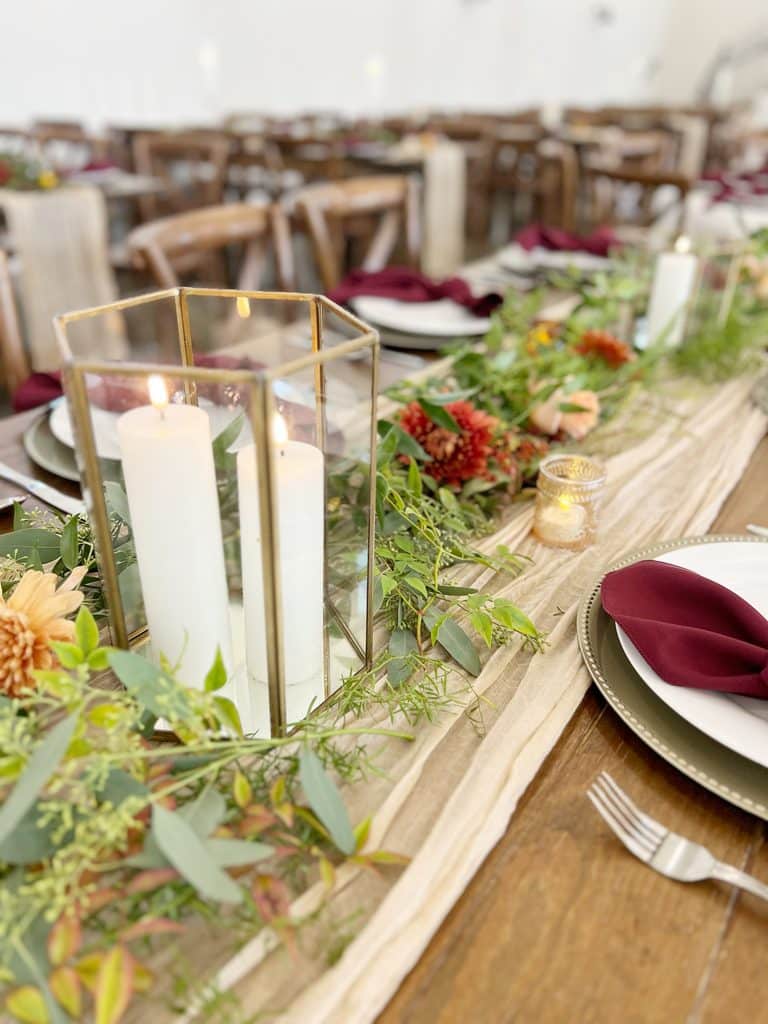 Candle lanterns and floral garland on an elegant banquet table