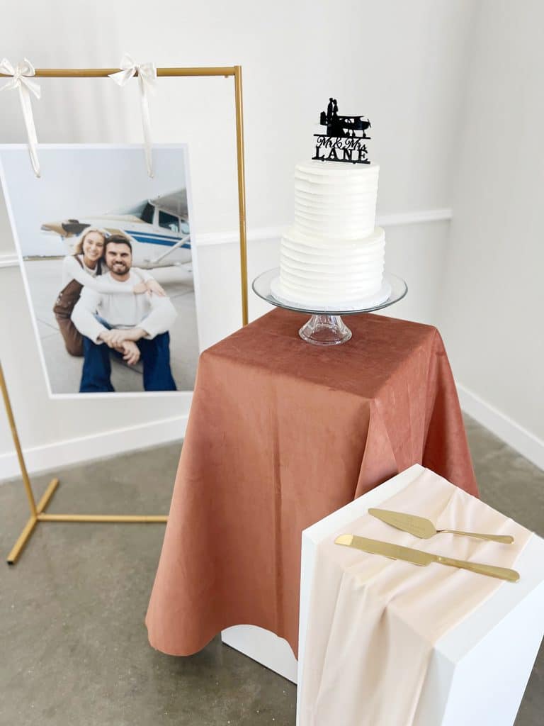 White wedding cake with airplane topper and couple portrait