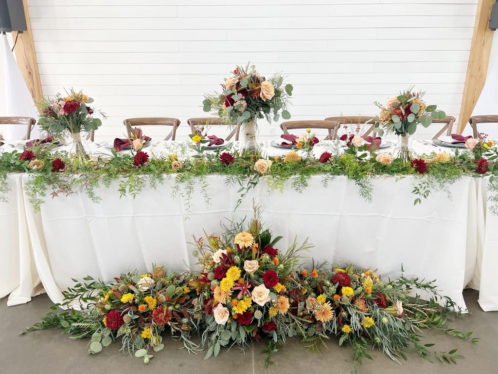 Floral wedding table with burgundy and peach blooms