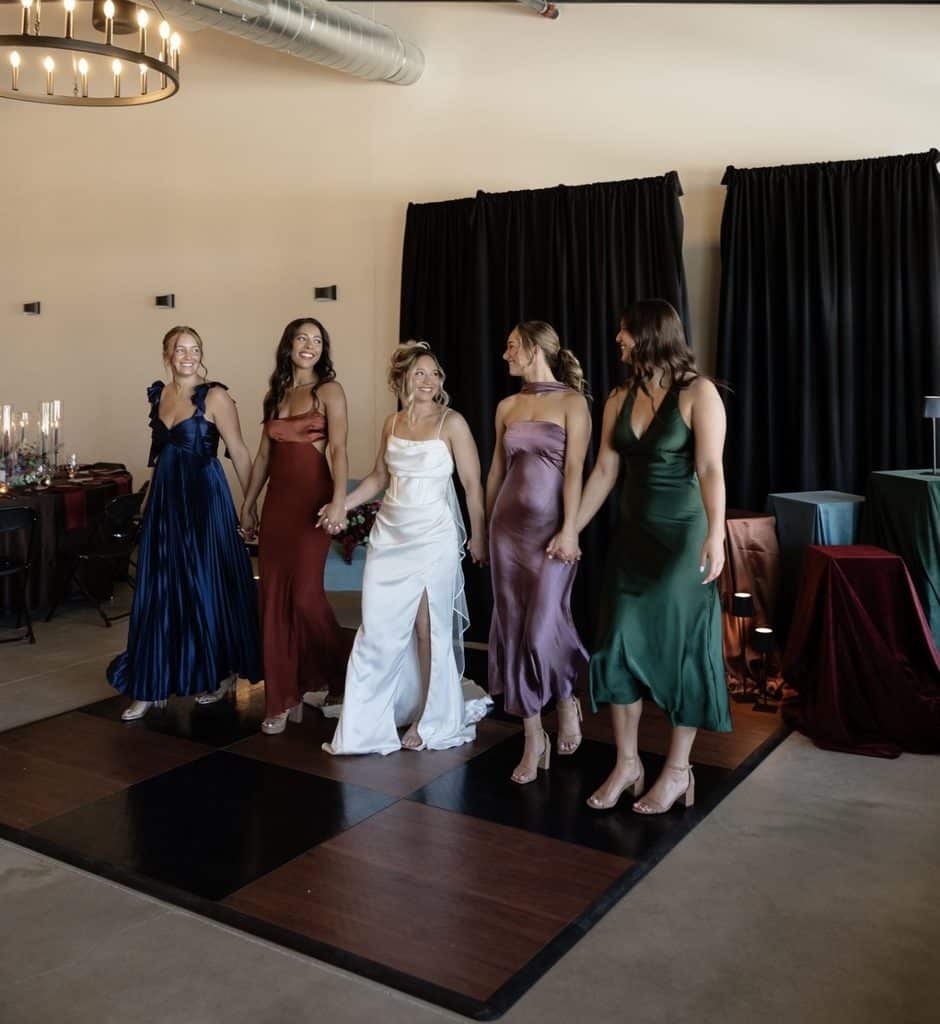 Bride and bridesmaids holding hands on wedding dance floor
