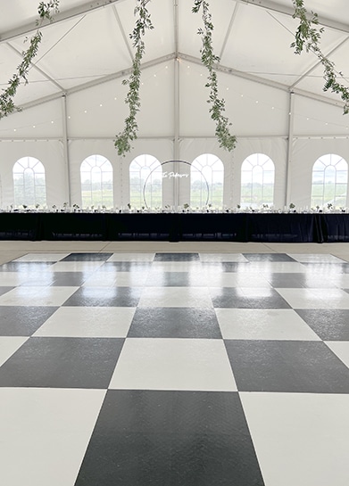 Black-and-white checkered dance floor in decorated wedding tent