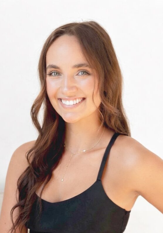 Smiling woman with long brown hair in black top